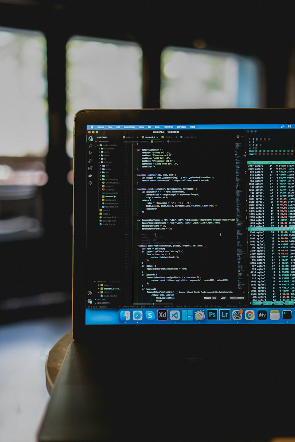 Laptop screen displaying programming code on a textured desk.